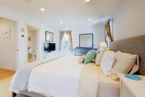 a bedroom with a large white bed with pillows at Modern Beach & Town Getaway in Falmouth