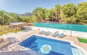 a swimming pool with lounge chairs next to a fence at Amazing Home In Iznjar With 4 Bedrooms, Wifi And Private Swimming Pool in Iznájar