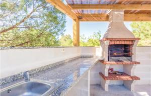 a outdoor kitchen with a pizza oven on the counter at Awesome Home In Iznájar in Iznájar +34 photos