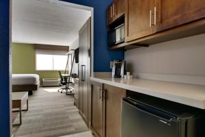 a kitchen with a counter and a room with a bed at Holiday Inn Express & Suites Wapakoneta, an IHG Hotel in Wapakoneta