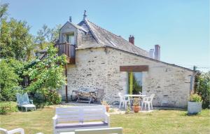 una antigua casa de piedra con mesa y sillas en Stunning Home In St Jean Des Mauvrets With Kitchen, en Saint-Mélaine-sur-Aubance