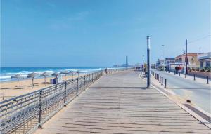un paseo marítimo de madera con sombrillas en la playa en Pet Friendly Apartment, en La Mata