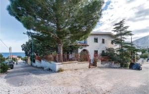 a house with a tree in front of a driveway at Casa Camilla 2 in Cala Gonone