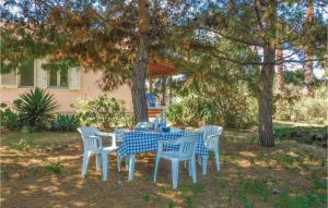 einen blauen und weißen Tisch und Stühle unter einem Baum in der Unterkunft La Pineta in Lido Signorino