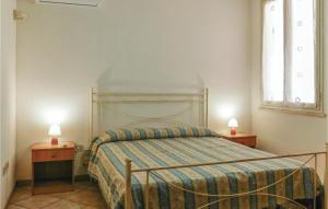 Lido SignorinoにあるLa Pinetaのベッドルーム1室(ベッド1台、ランプ付きテーブル2台付)