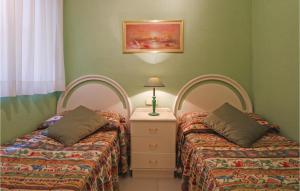 ピネダ・デ・マールにあるAmazing Apartment In Pineda De Mar With 2 Bedrooms And Outdoor Swimming Poolの緑の壁のドミトリールーム ベッド2台
