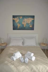 a bed with two towels and a map on the wall at Harmony Studio in Athens