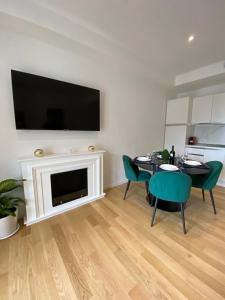 uma sala de estar com uma mesa e cadeiras e uma televisão em Barium Suite - Elegante Appartamento in Centro em Bari