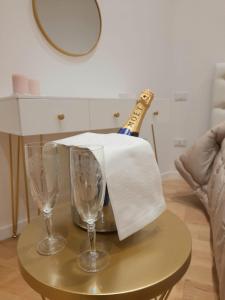 uma garrafa de champanhe e dois copos numa mesa em Barium Suite - Elegante Appartamento in Centro em Bari