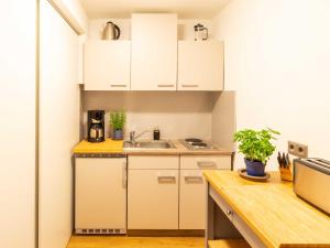 een kleine keuken met witte kasten en een wastafel bij Ferienwohnung Gode Tied in Bergen auf Rügen