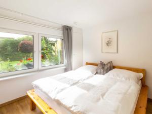 a bedroom with a white bed and a window at Ferienwohnung Gode Tied in Bergen auf Rügen