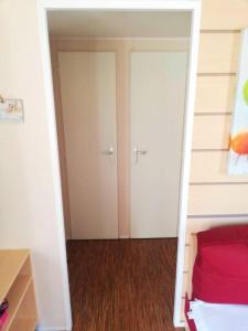 Schlafzimmer mit zwei Schränken und einem Bett mit roter Bettwäsche in der Unterkunft Bungalow confortable à Vias avec piscine partagée in Vias