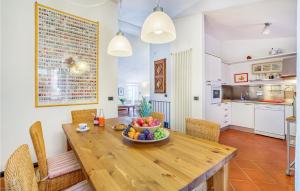 - une cuisine et une salle à manger avec une table en bois et un bol de fruits dans l'établissement Awesome Home In Moneglia With Kitchen, à Moneglia