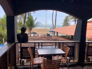 een tafel en stoelen op een balkon met uitzicht op het strand bij Soul Lounge Hostel in São Luís