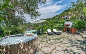 une terrasse avec un bain à remous, des chaises et un parasol dans l'établissement Awesome Home In Moneglia With Kitchen, à Moneglia