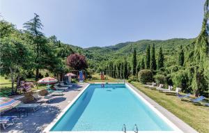 a swimming pool with chairs and trees and mountains in the background at Casa Samuele in Polvano