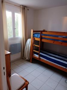 1 Schlafzimmer mit 2 Etagenbetten und einer Badewanne in der Unterkunft Maison charmante à Vias + Piscine partagée in Vias