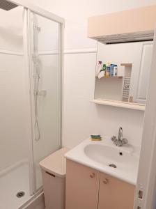 ein weißes Badezimmer mit Waschbecken und Dusche in der Unterkunft Maison charmante à Vias + Piscine partagée in Vias