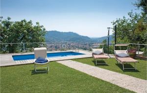 two chairs and a swimming pool in the grass at Casa Fulvia in Camaiore