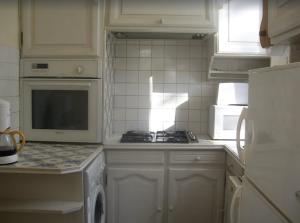 a kitchen with white cabinets and a stove and a microwave at Château Fontclaire in Pons +12 photos