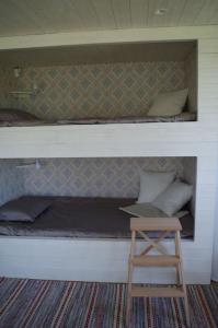 a bunk bed with a wooden stool in a room at Ekereds Gårdsstuga in Dalstorp