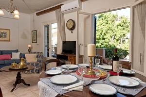 a dining room with a table with plates and wine glasses at Corfu Garitsa Spacious Apartment in Corfu