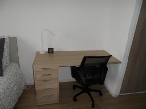 a desk with a lamp and a chair next to a bed at # STUDIO BON EMPLACEMENT AVEC PARKING # in Illzach