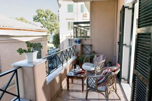 a balcony with two chairs and a table on it at Corfu Garitsa Spacious Apartment in Corfu