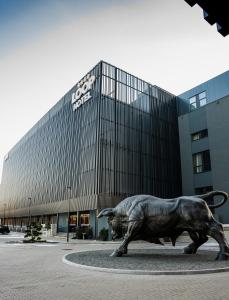 a statue of a bull in front of a building at Loop Hotel Vilnius in Vilnius