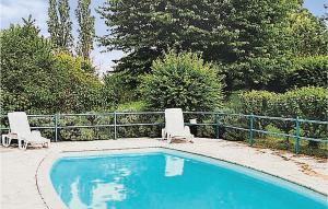 2 sillas sentadas junto a una piscina en Amazing Home In Ladornac With Kitchen, en La Dornac