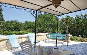 a patio with a table and chairs under a canopy at Nice Home In Ladornac With 2 Bedrooms, Private Swimming Pool And Outdoor Swimming Pool in La Dornac