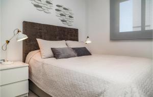 ein Schlafzimmer mit einem weißen Bett und zwei Lampen darauf in der Unterkunft Nice Apartment In Los Arenales Del Sol in Arenales del Sol