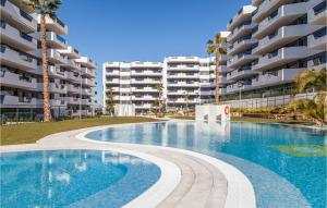 einem Pool vor einem großen Apartmenthaus in der Unterkunft Nice Apartment In Los Arenales Del Sol in Arenales del Sol