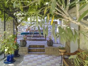 un patio con árboles, bancos y una mesa en La Douce France en Les Taillades