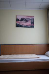 Bett in einem Zimmer mit einem Bild an der Wand in der Unterkunft RadlStadl - Brauhaus und Hotel in Kaarst