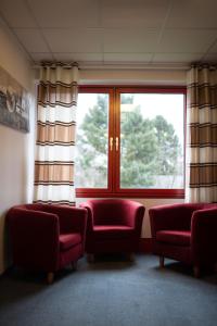 a waiting room with two red chairs and a window at RadlStadl - Brauhaus und Hotel in Kaarst