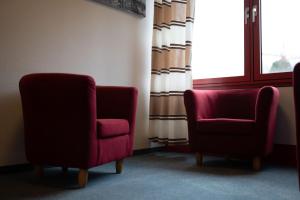 duas cadeiras sentadas num quarto com uma janela em RadlStadl - Brauhaus und Hotel em Kaarst