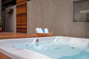 a bath tub with a basket of towels in a bathroom at Casa ao mar da Praia de Pirangi por Carpediem in Parnamirim