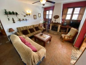 een woonkamer met een bank en een tafel bij Casa el saladillo in Valle de Abdalagís
