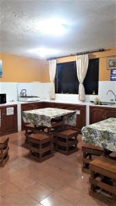 a kitchen with a table and benches in a room at La Estancia de Runtún Km 7 in Baños