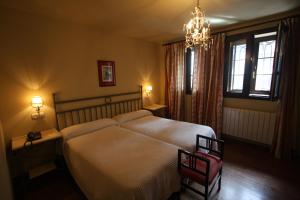 Un dormitorio con una cama grande y una lámpara de araña. en Hotel Casona del Busto, en Pravia
