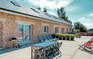 un patio con mesa y sillas y un edificio de ladrillo en Amazing Home In Roisel With Kitchen, en Roisel
