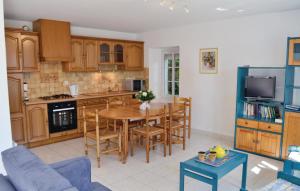 a kitchen with a table and a dining room at Nice Home In Carnac With 3 Bedrooms And Wifi in Carnac