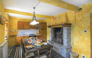 uma cozinha com uma mesa e uma lareira de pedra em Amazing Home In Montefegatesi With Wifi em Tereglio