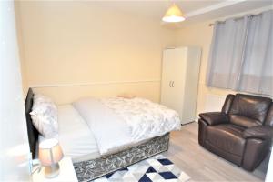 a bedroom with a bed and a leather chair at London Zone 1, 3bedroom Maisonette with a view in London