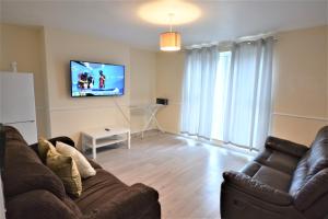 a living room with a couch and a flat screen tv at London Zone 1, 3bedroom Maisonette with a view in London