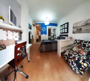 アリカンテにあるMediterráneo beach Muñozのベッドルーム1室(ベッド1台、デスク、ソファ付)