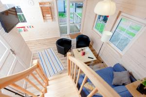 a tiny house with a staircase and a living room at Camping Pomona in Niechorze