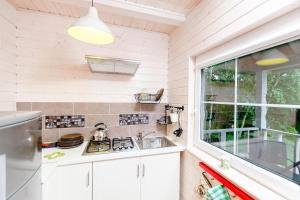 uma cozinha com um lavatório e uma janela em Camping Pomona em Niechorze