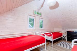 a bedroom with two beds and a red blanket at Camping Pomona in Niechorze